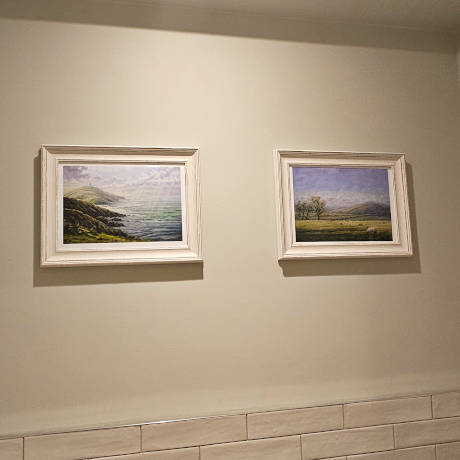 Two framed fine art landscape prints hanging on a wall